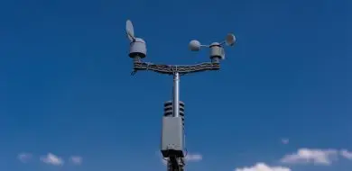 Weather station with IoT sensor installed outdoors on a mast, connected via wireless M2M connectivity